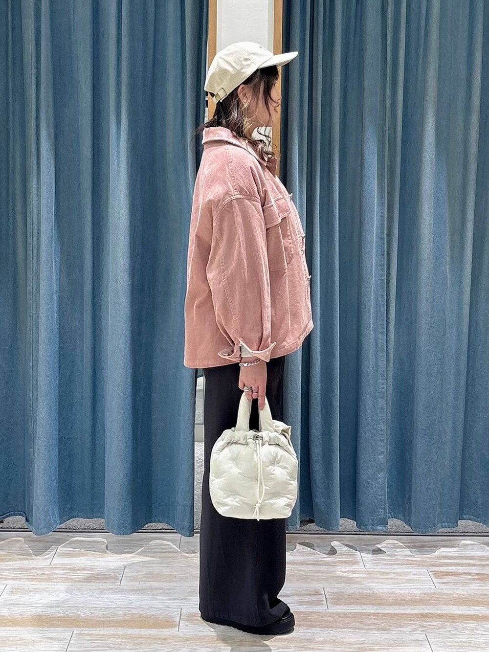 ブラック系のブーツ、ホワイト系のショルダーバッグ、ホワイト系のスウェットを着用したレディースの冬コーディネートの2枚目の写真