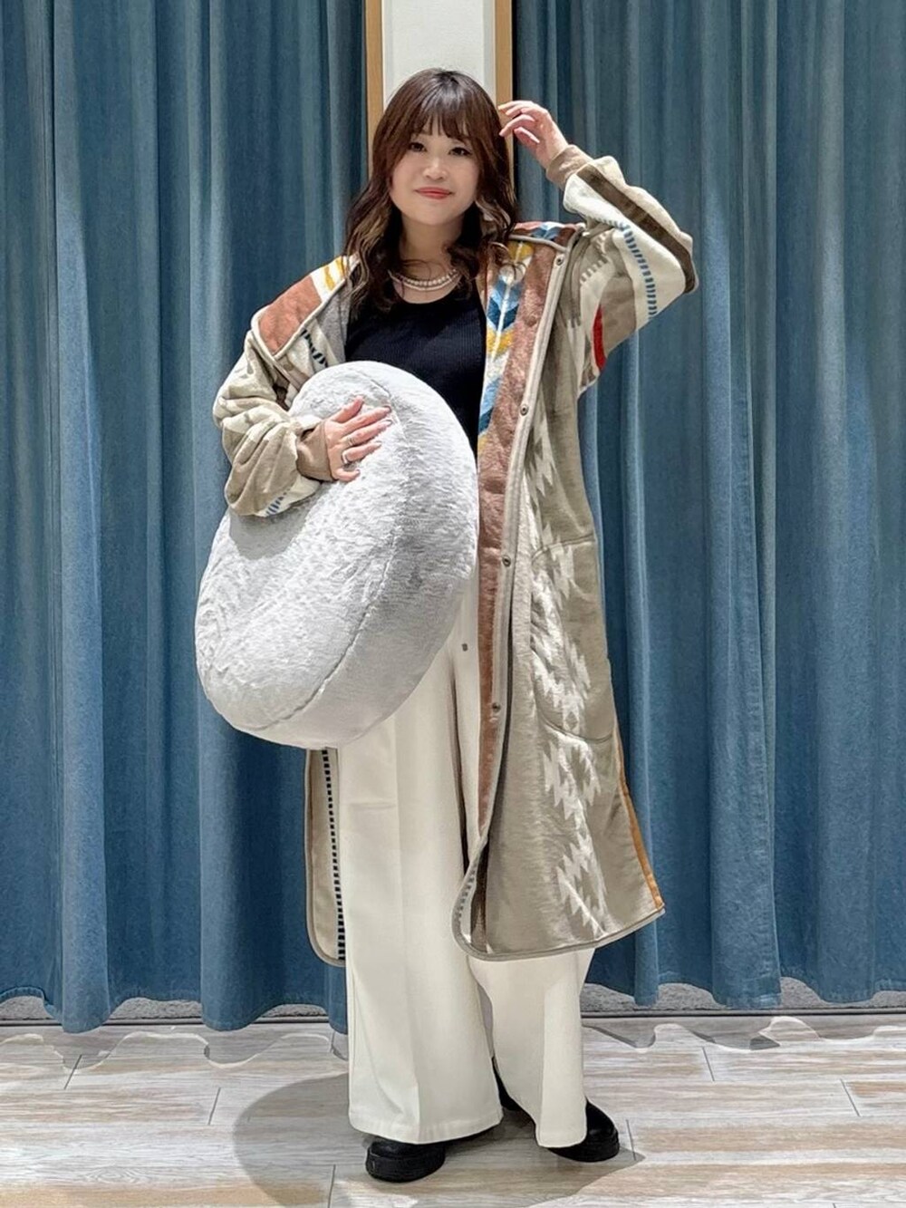 ベージュ系のその他パンツ、ブラック系のブーツ、グレー系のクッション/クッションカバーを着用したレディースの秋コーディネートの4枚目の写真