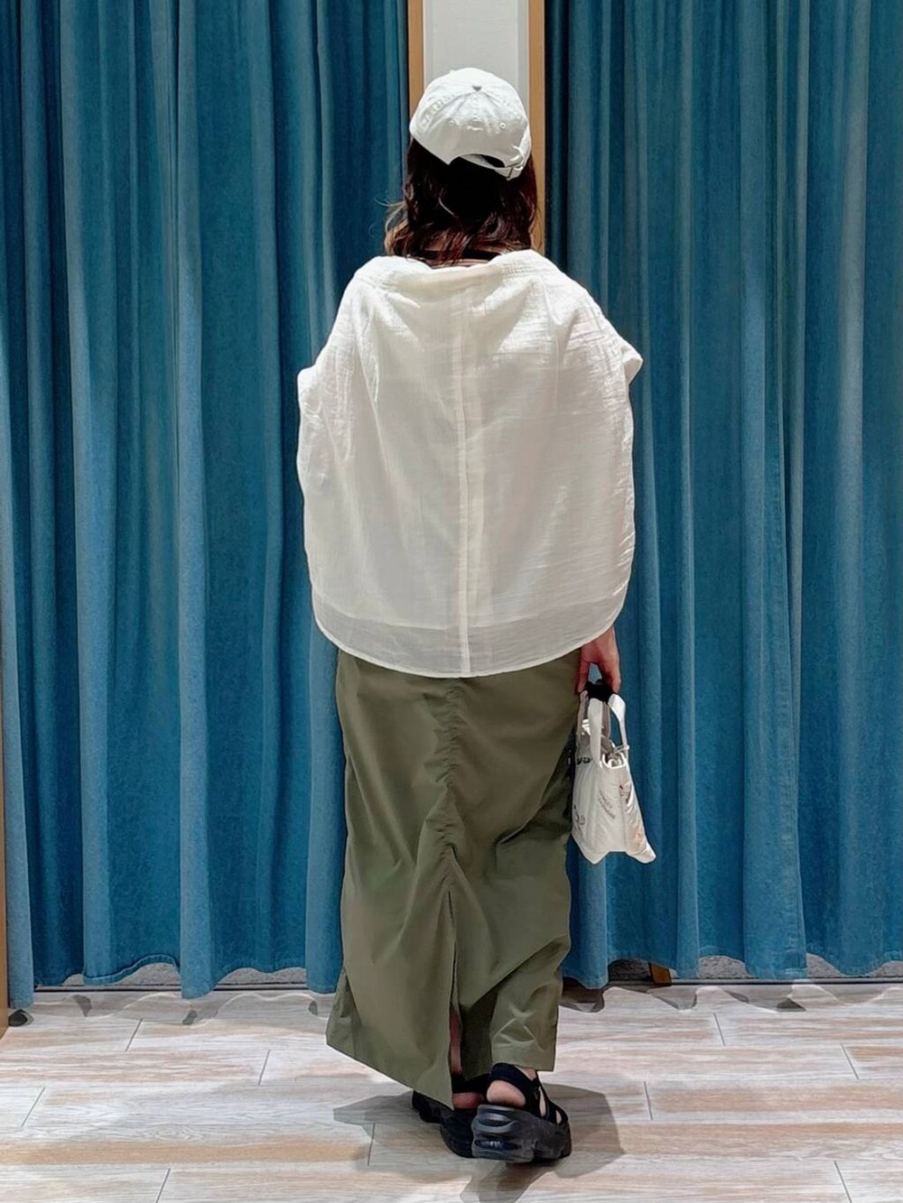 ホワイト系のシャツ/ブラウス、グリーン系のスカート、ホワイト系のトートバッグを着用したレディースの夏コーディネートの3枚目の写真