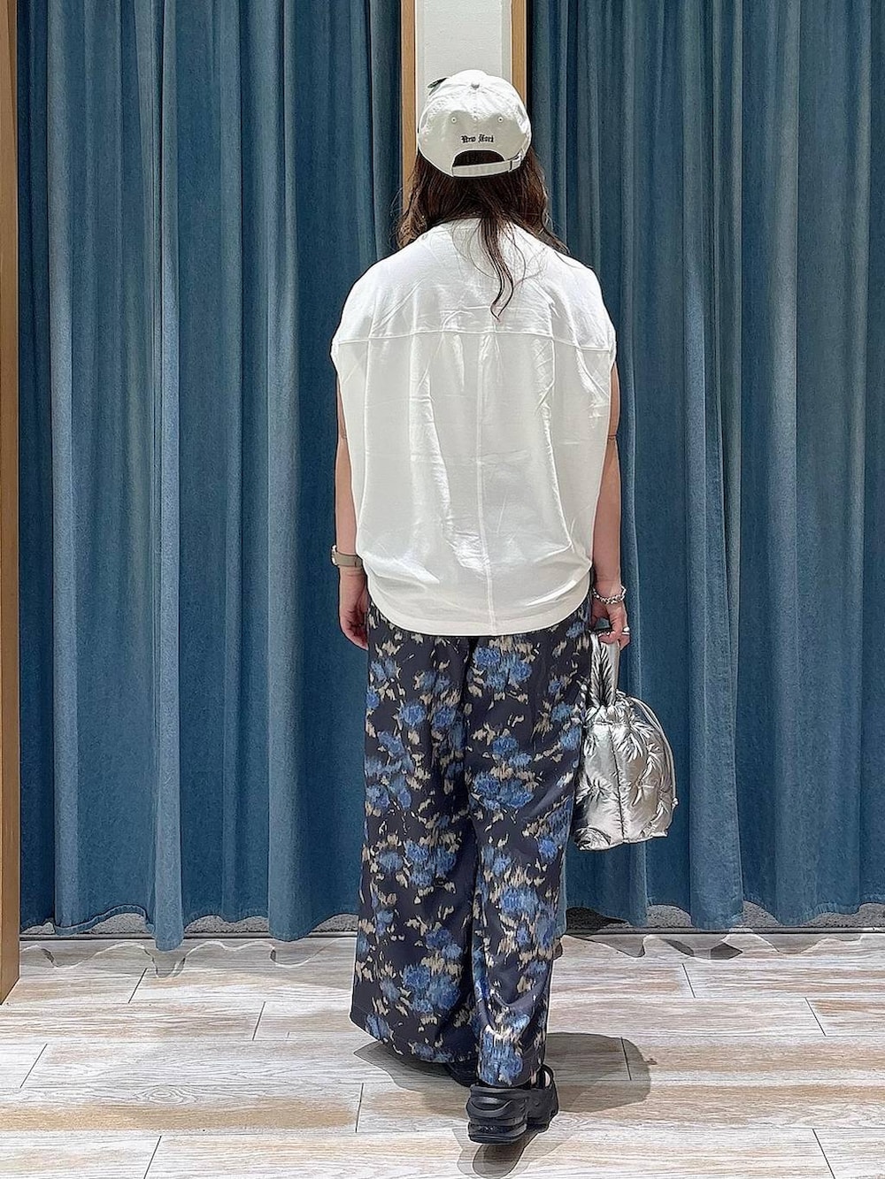 シルバー系のショルダーバッグ、ホワイト系のTシャツ/カットソー、ブラック系のその他パンツを着用したレディースの春コーディネートの3枚目の写真