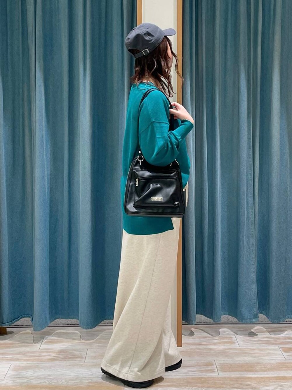 グリーン系のカーディガン/ボレロ、ベージュ系のスウェットパンツ、ブラック系のサンダルを着用したレディースの春コーディネートの2枚目の写真