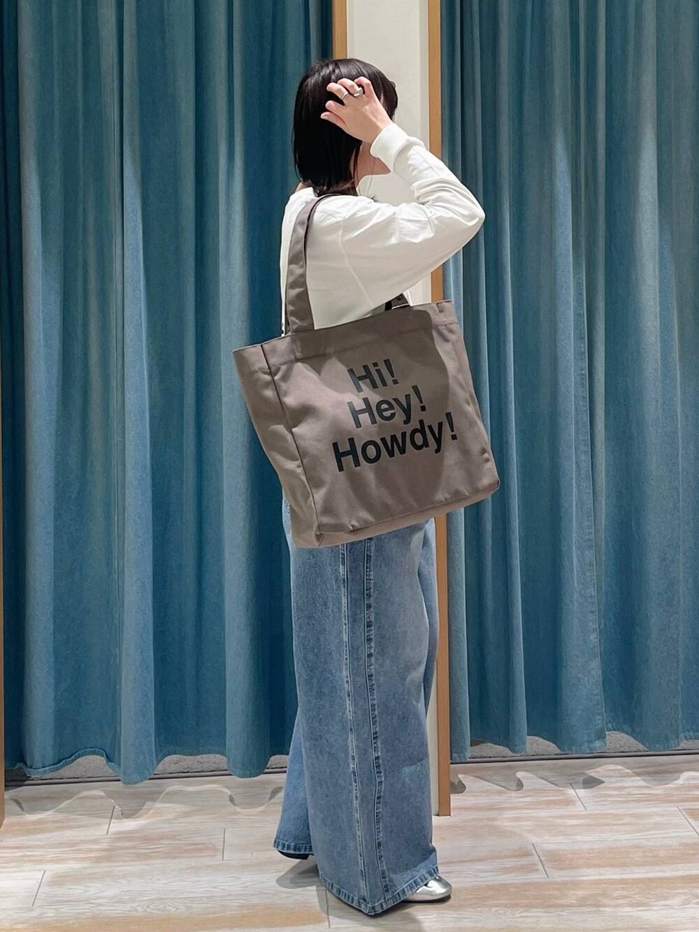 ブルー系のデニムパンツ、ホワイト系のTシャツ/カットソー、グリーン系のトートバッグを着用したレディースの冬コーディネートの3枚目の写真