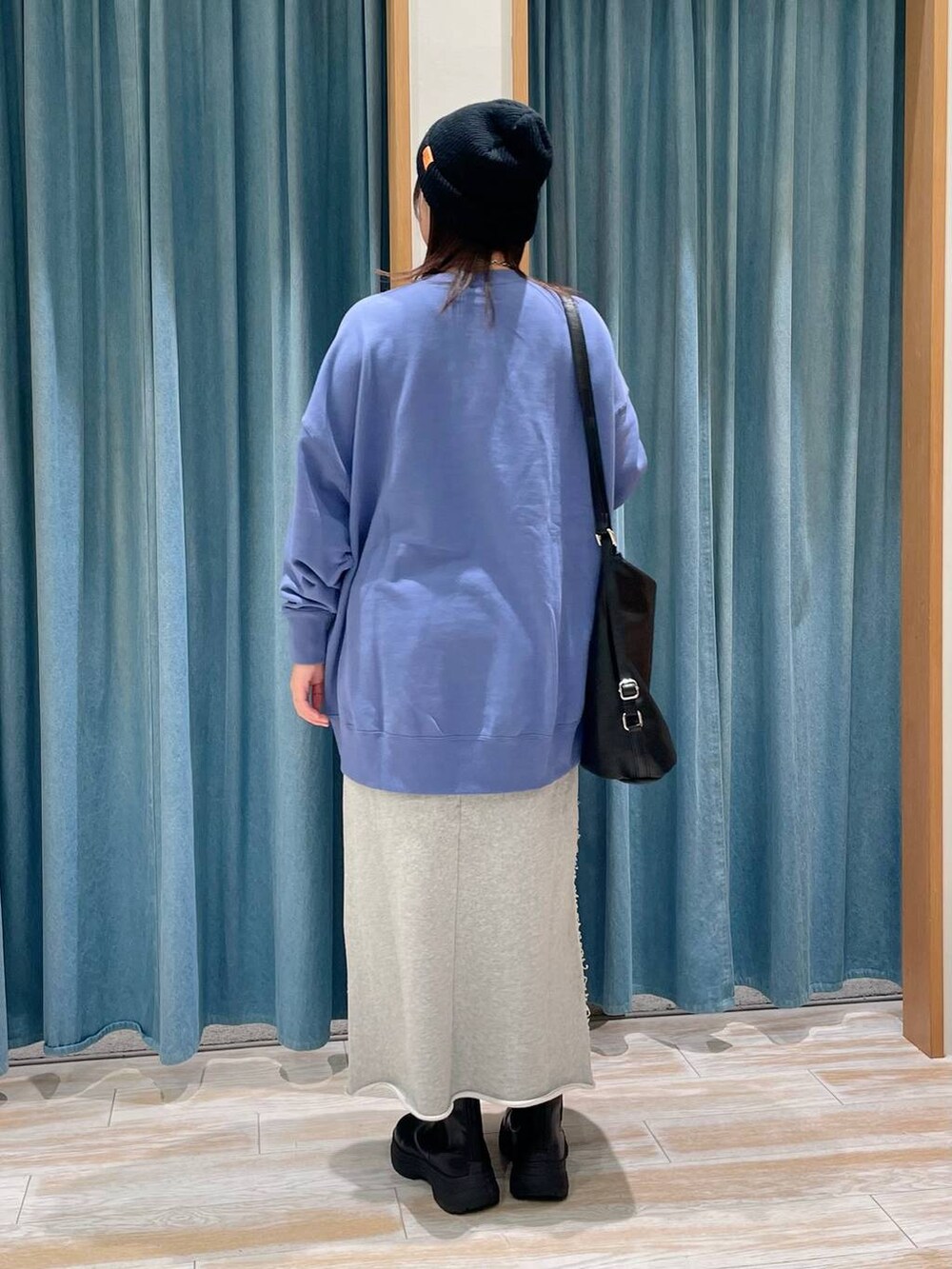 ブラック系のブーツ、ブラック系のショルダーバッグ、ブルー系のスウェットを着用したレディースの冬コーディネートの3枚目の写真