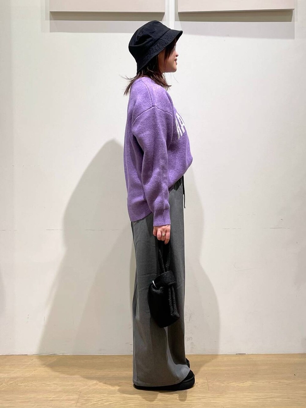 グレー系のその他パンツ、ブラック系のブーツ、パープル系のニット/セーターを着用したレディースの秋コーディネートの2枚目の写真