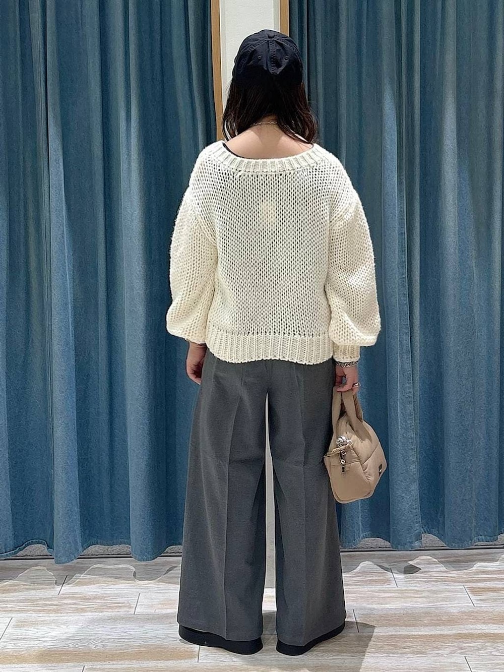 グレー系のその他パンツ、ベージュ系のボストンバッグ、ホワイト系のニット/セーターを着用したレディースの冬コーディネートの3枚目の写真