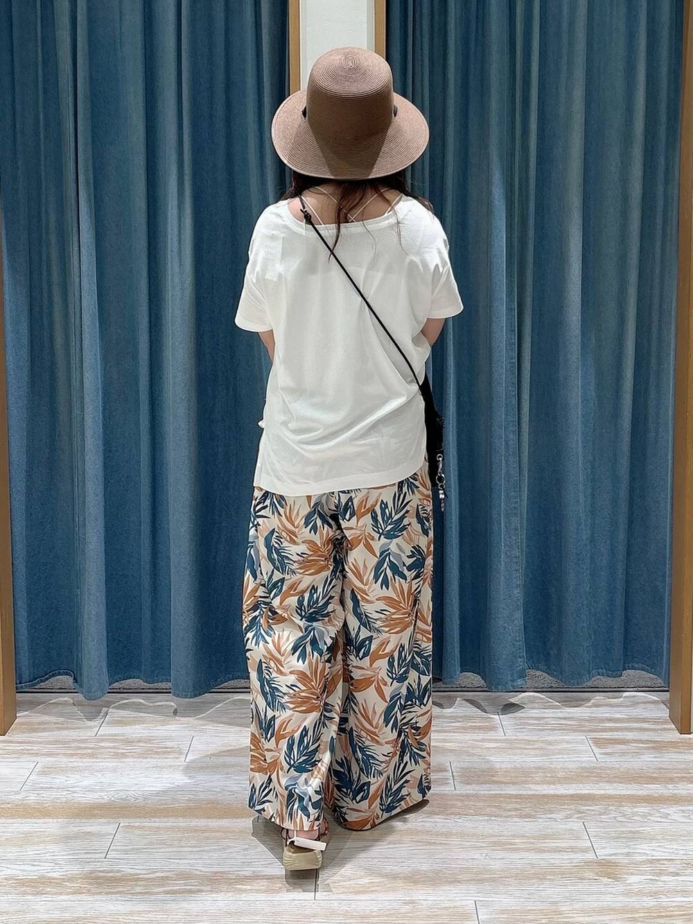 ブラック系のショルダーバッグ、ホワイト系のTシャツ/カットソー、ゴールド系のサンダルを着用したレディースの春コーディネートの3枚目の写真