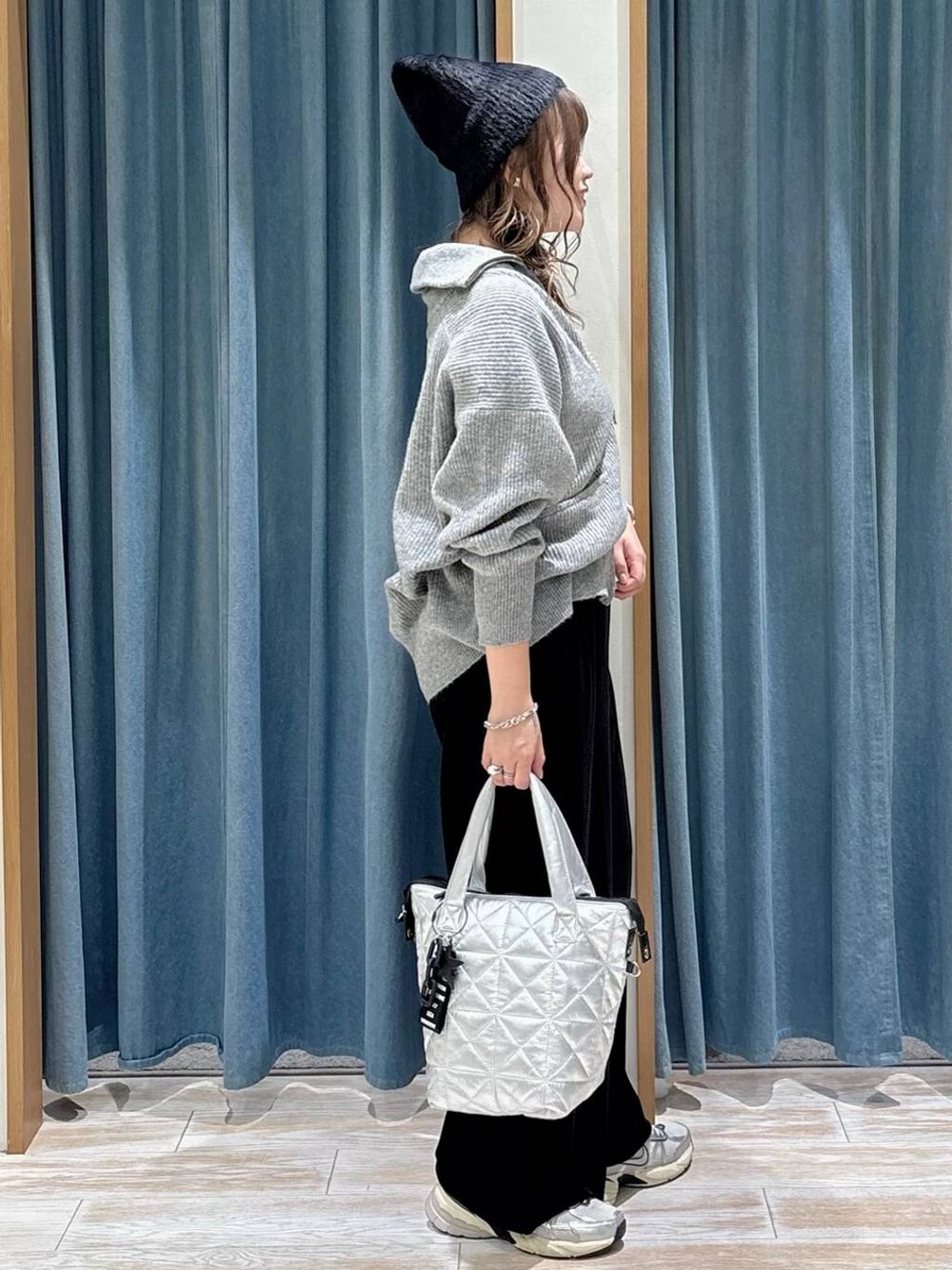 ブラック系のその他パンツ、シルバー系のトートバッグ、グレー系のニット/セーターを着用したレディースの秋コーディネートの2枚目の写真