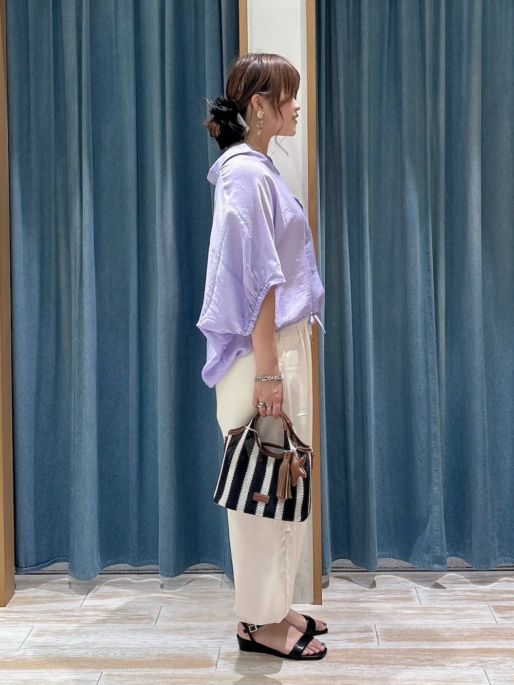 ベージュ系のその他パンツ、ブルー系のショルダーバッグ、ブラック系のサンダルを着用したレディースの夏コーディネートの2枚目の写真
