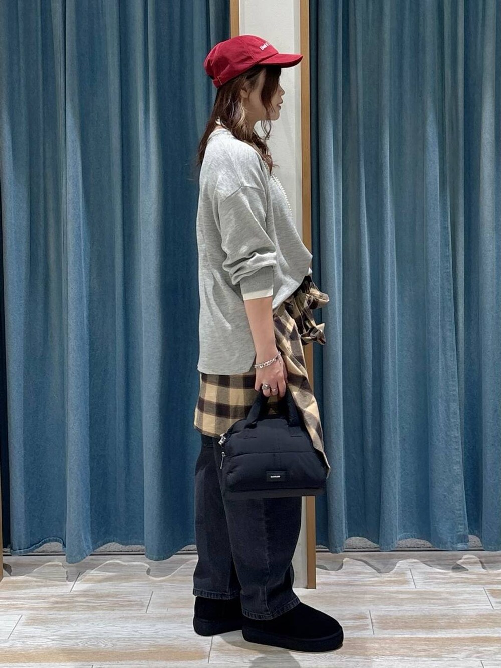 ブラック系のブーツ、グレー系のニット/セーター、ブラック系のボストンバッグを着用したレディースの秋コーディネートの2枚目の写真