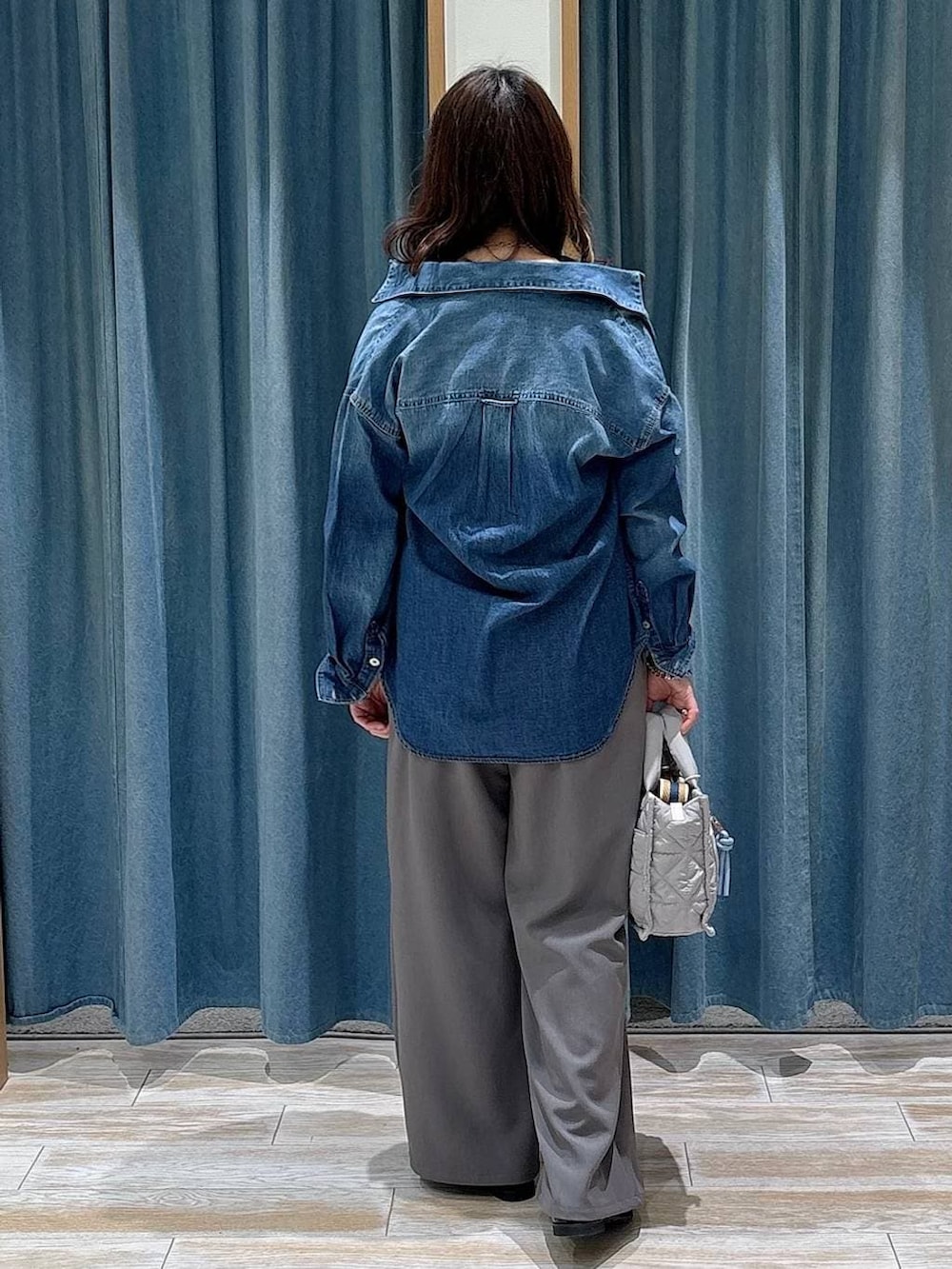 グレー系のショルダーバッグ、ブラック系のローファー、ブルー系のシャツ/ブラウスを着用したレディースの冬コーディネートの3枚目の写真