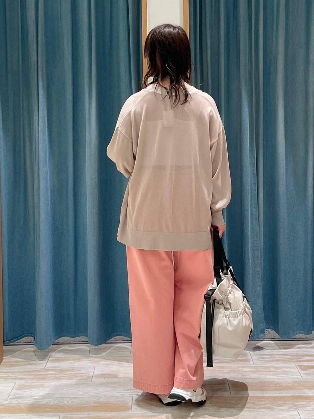 ホワイト系のキャミソール、ホワイト系のトートバッグ、ピンク系のデニムパンツを着用したレディースの春コーディネートの3枚目の写真