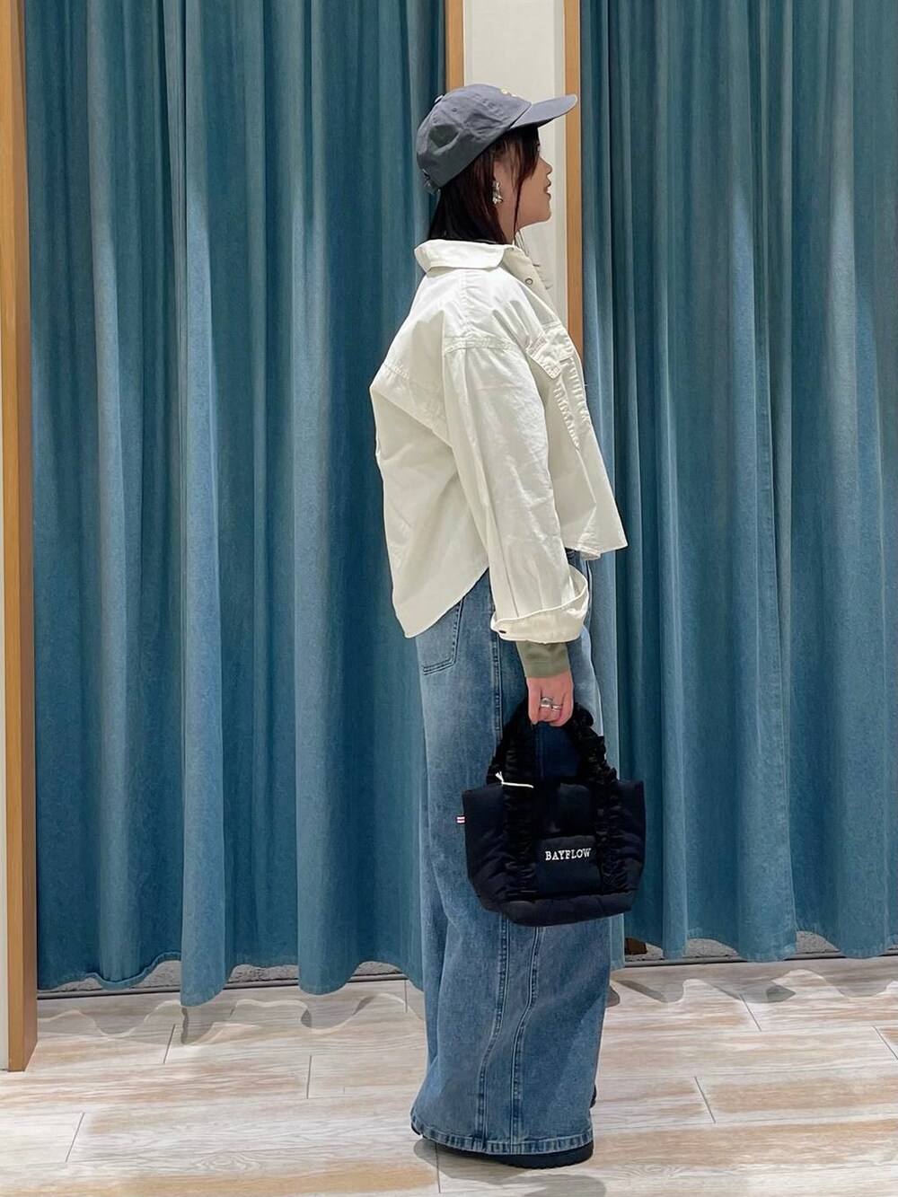 ブラック系のトートバッグ、ブルー系のデニムパンツ、その他のローファーを着用したレディースの冬コーディネートの2枚目の写真