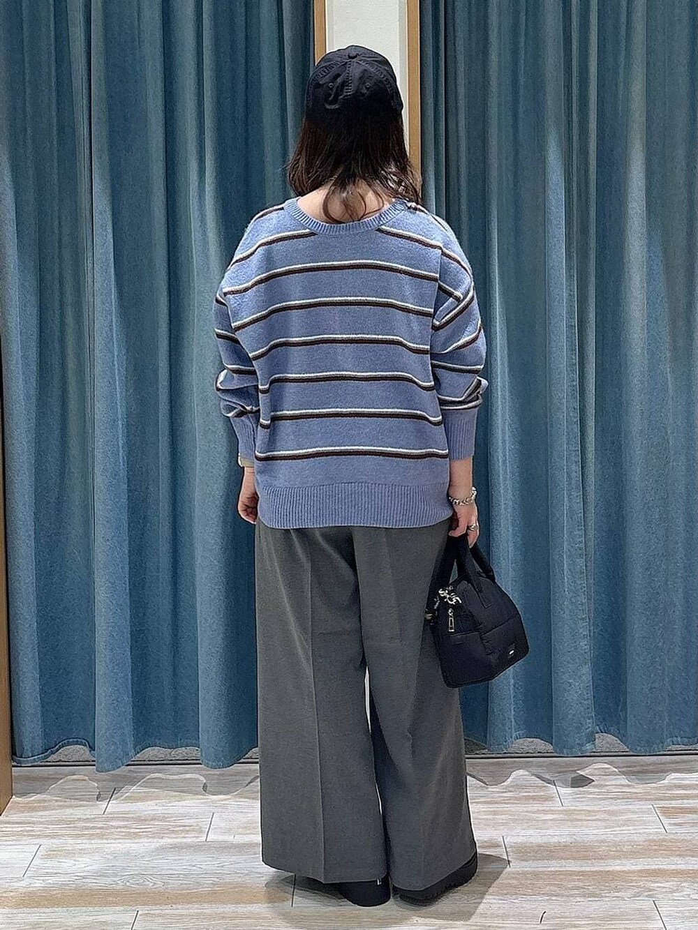 グレー系のその他パンツ、ブラック系のブーツ、ブラック系のボストンバッグを着用したレディースの冬コーディネートの3枚目の写真