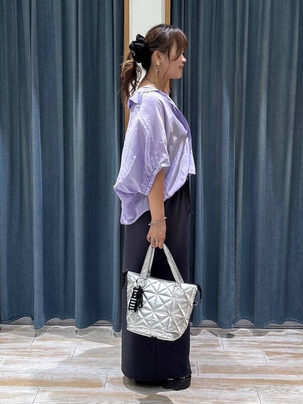 パープル系のシャツ/ブラウス、グレー系のその他パンツ、シルバー系のトートバッグを着用したレディースの夏コーディネートの2枚目の写真
