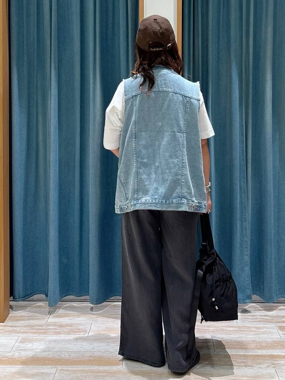 ブラック系のトートバッグ、ブラック系のその他パンツ、ホワイト系のTシャツ/カットソーを着用したレディースの夏コーディネートの3枚目の写真