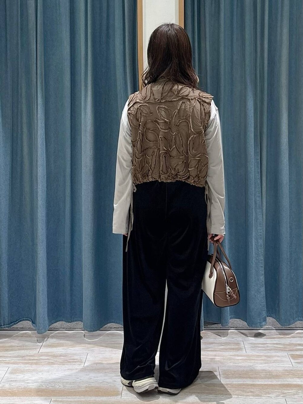 グレー系のTシャツ/カットソー、ホワイト系のハンドバッグ、ブラック系のその他パンツを着用したレディースの秋コーディネートの3枚目の写真