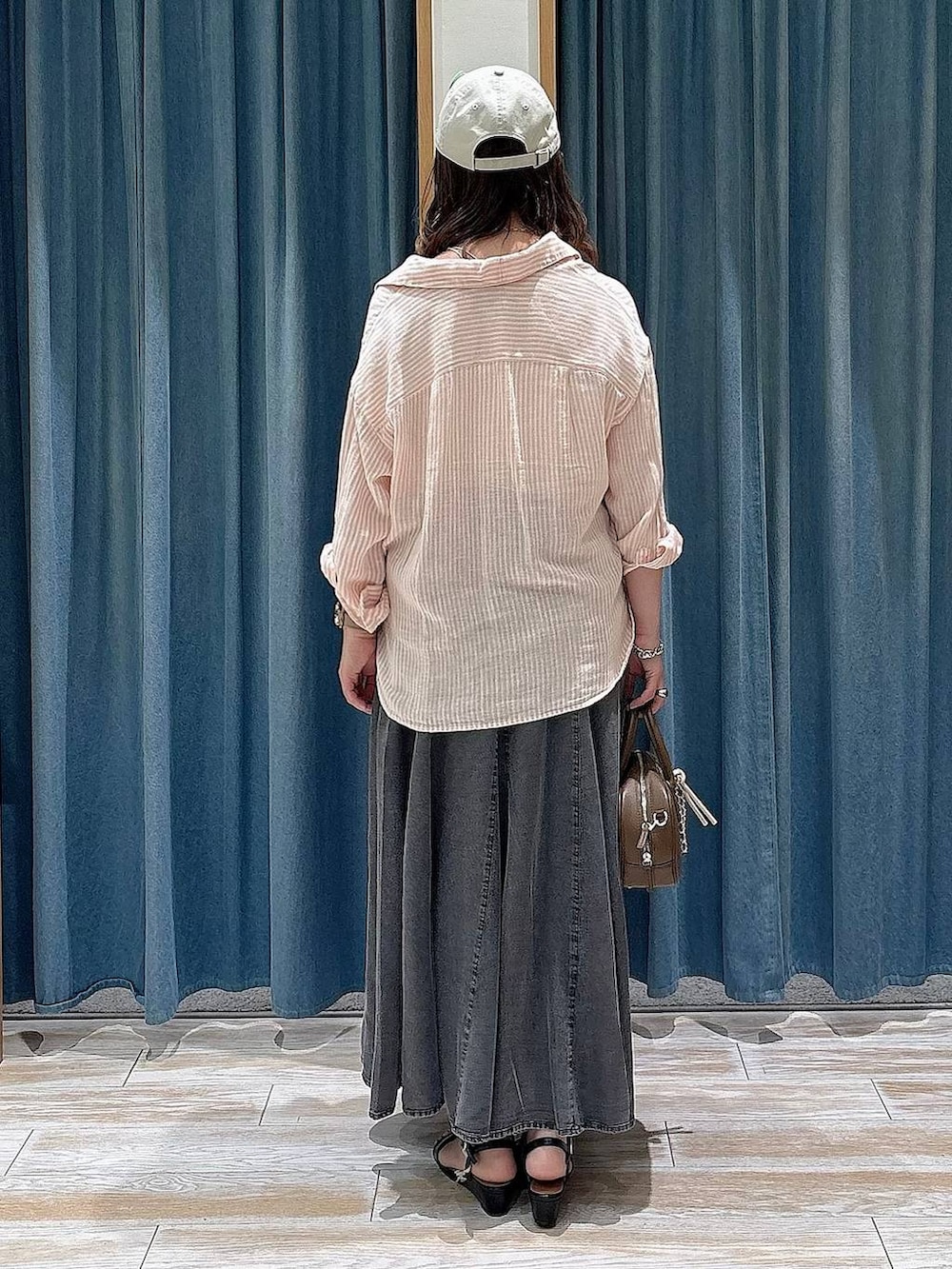 ピンク系のシャツ/ブラウス、ブラウン系のハンドバッグ、ブラック系のサンダルを着用したレディースの春コーディネートの3枚目の写真