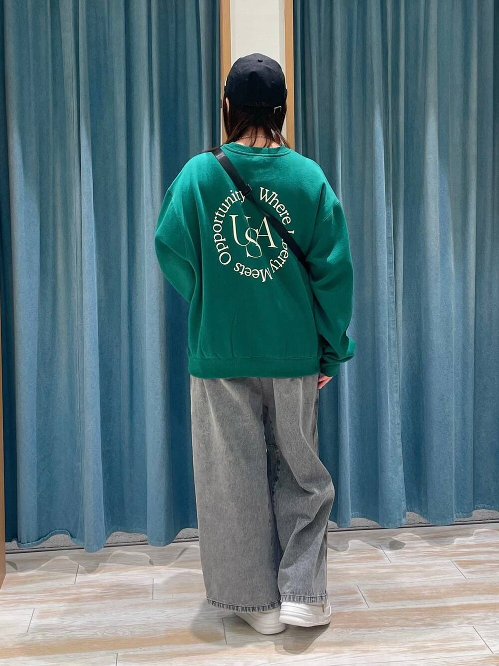 ホワイト系のスニーカー、グレー系のデニムパンツ、グリーン系のスウェットを着用したレディースの冬コーディネートの3枚目の写真