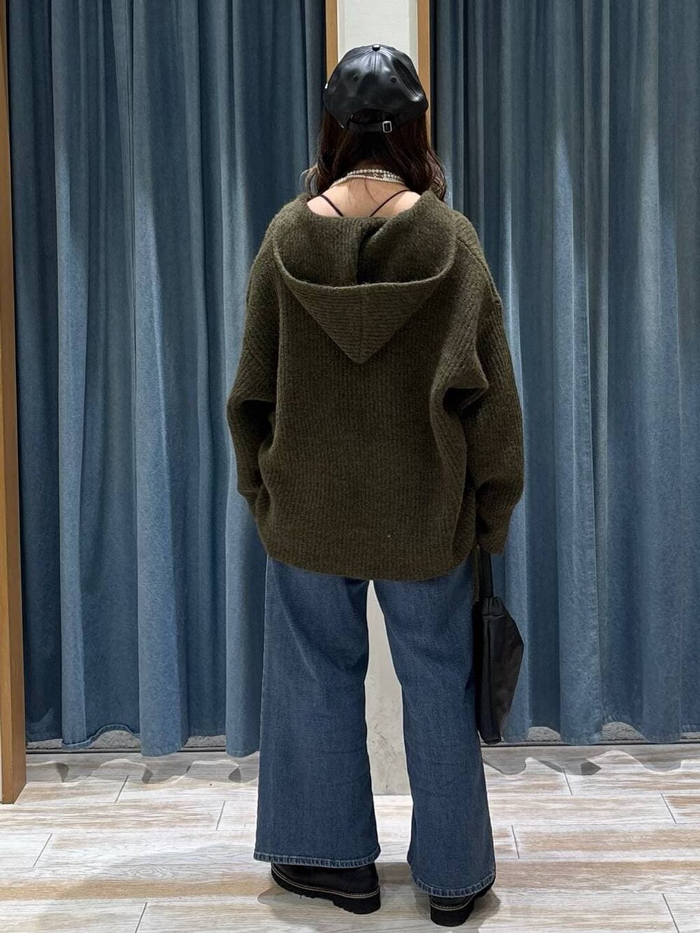 ブラック系のローファー、ブルー系のデニムパンツ、ブラック系のハンドバッグを着用したレディースの秋コーディネートの3枚目の写真