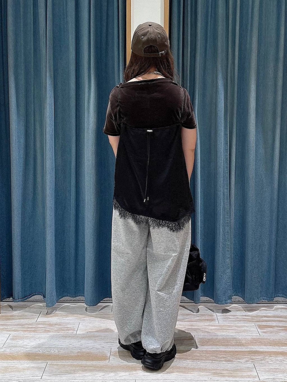 ブラック系のスニーカー、グレー系のスウェットパンツ、ブラウン系のTシャツ/カットソーを着用したレディースの夏コーディネートの3枚目の写真