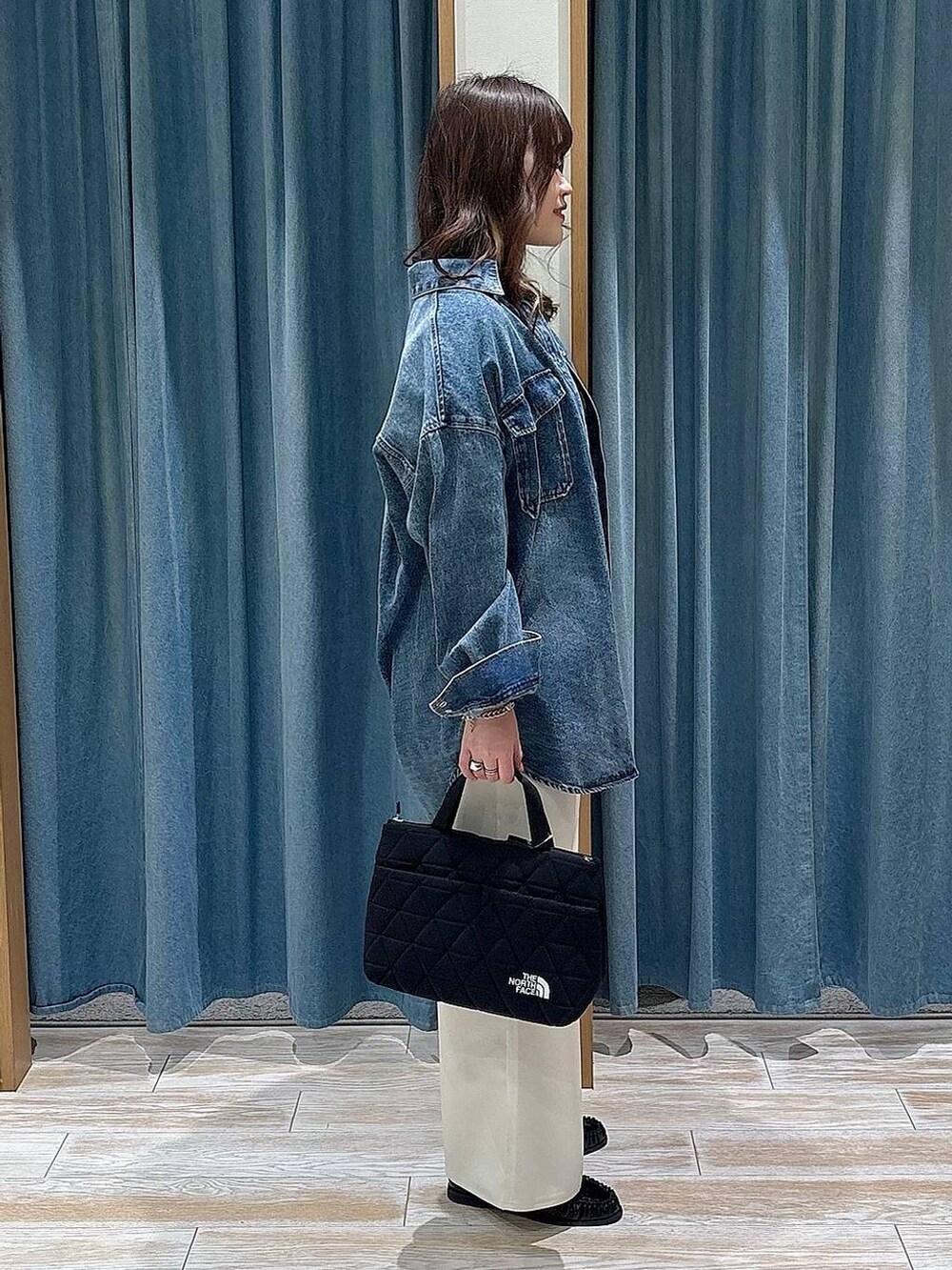 ブラック系のTシャツ/カットソー、ブラック系のトートバッグ、ホワイト系のその他パンツを着用したレディースの冬コーディネートの2枚目の写真