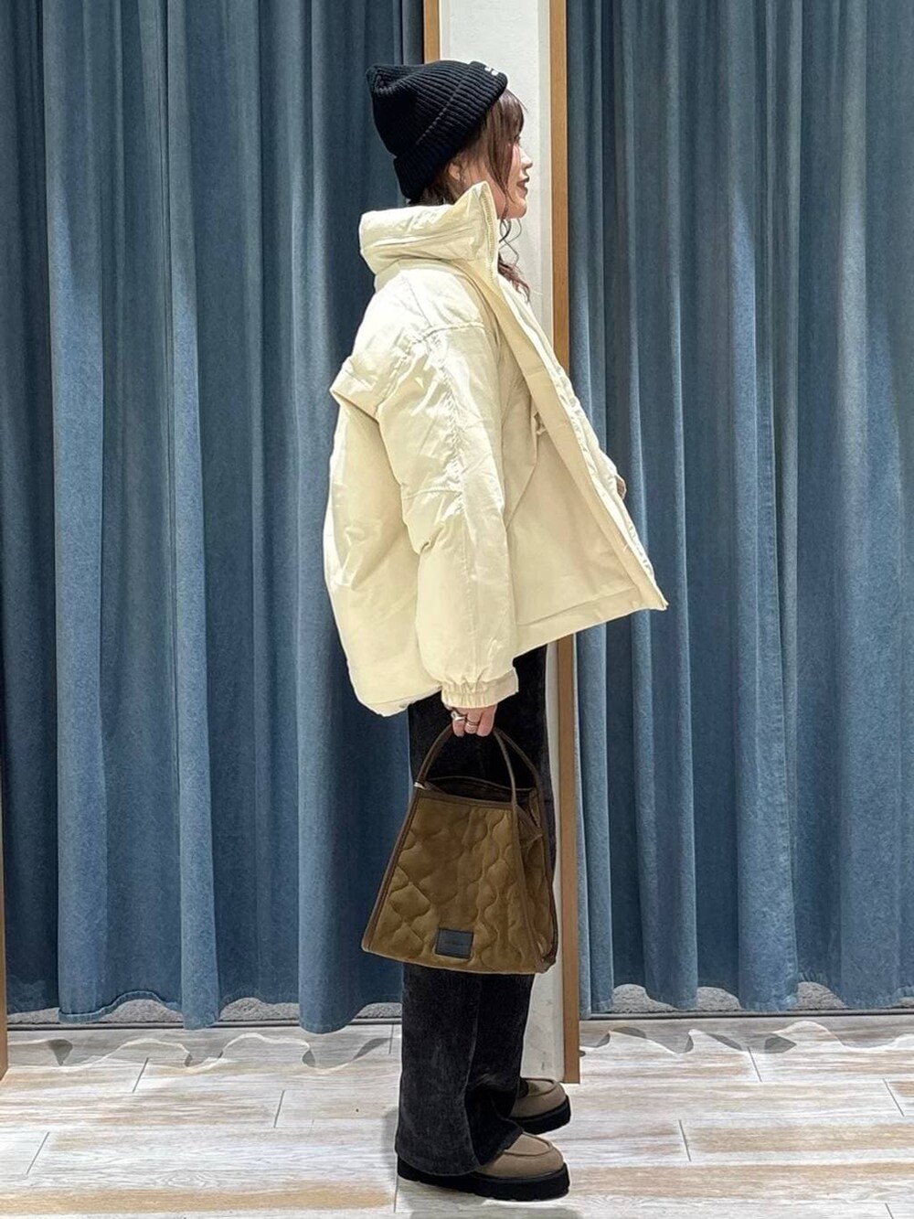 レッド系のニット/セーター、ホワイト系のダウンジャケット/コート、イエロー系のハンドバッグを着用したレディースの秋コーディネートの2枚目の写真