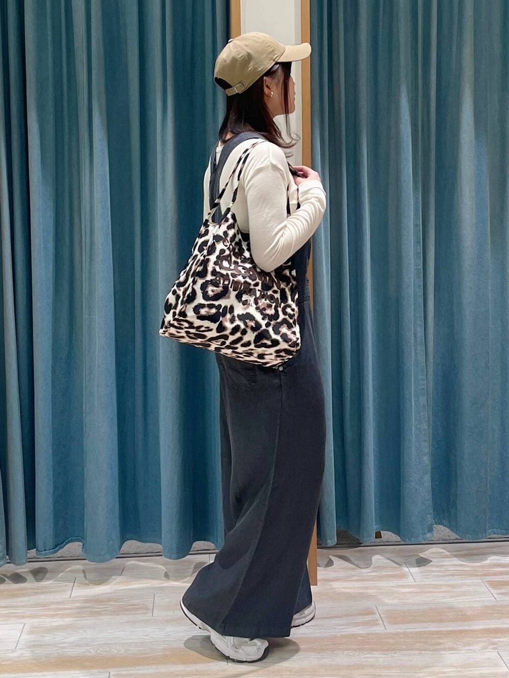 ベージュ系のトートバッグ、ホワイト系のTシャツ/カットソー、ベージュ系のキャップを着用したレディースの春コーディネートの2枚目の写真