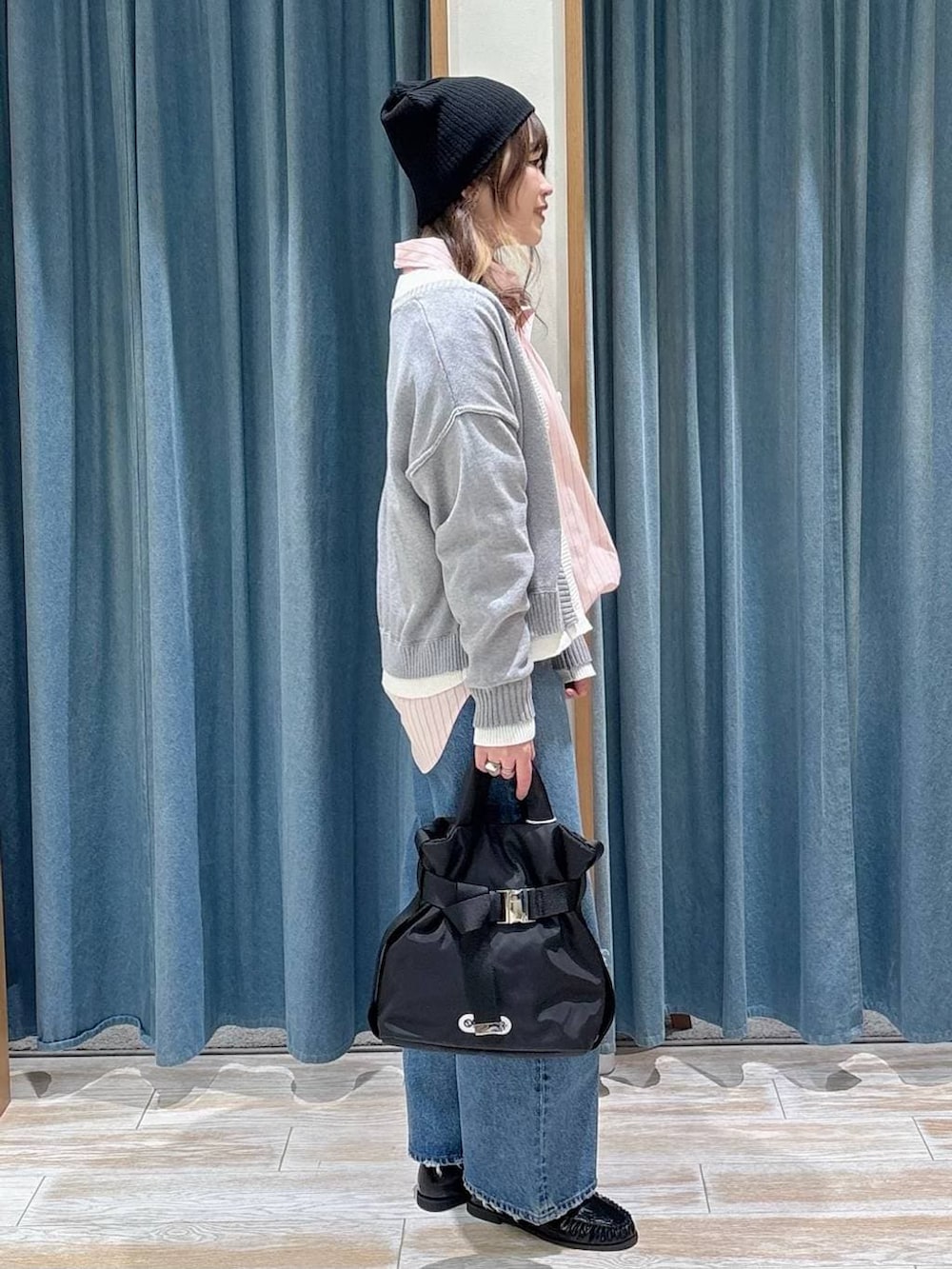 ブラック系のトートバッグ、ブルー系のデニムパンツ、ブラック系のローファーを着用したレディースの冬コーディネートの2枚目の写真