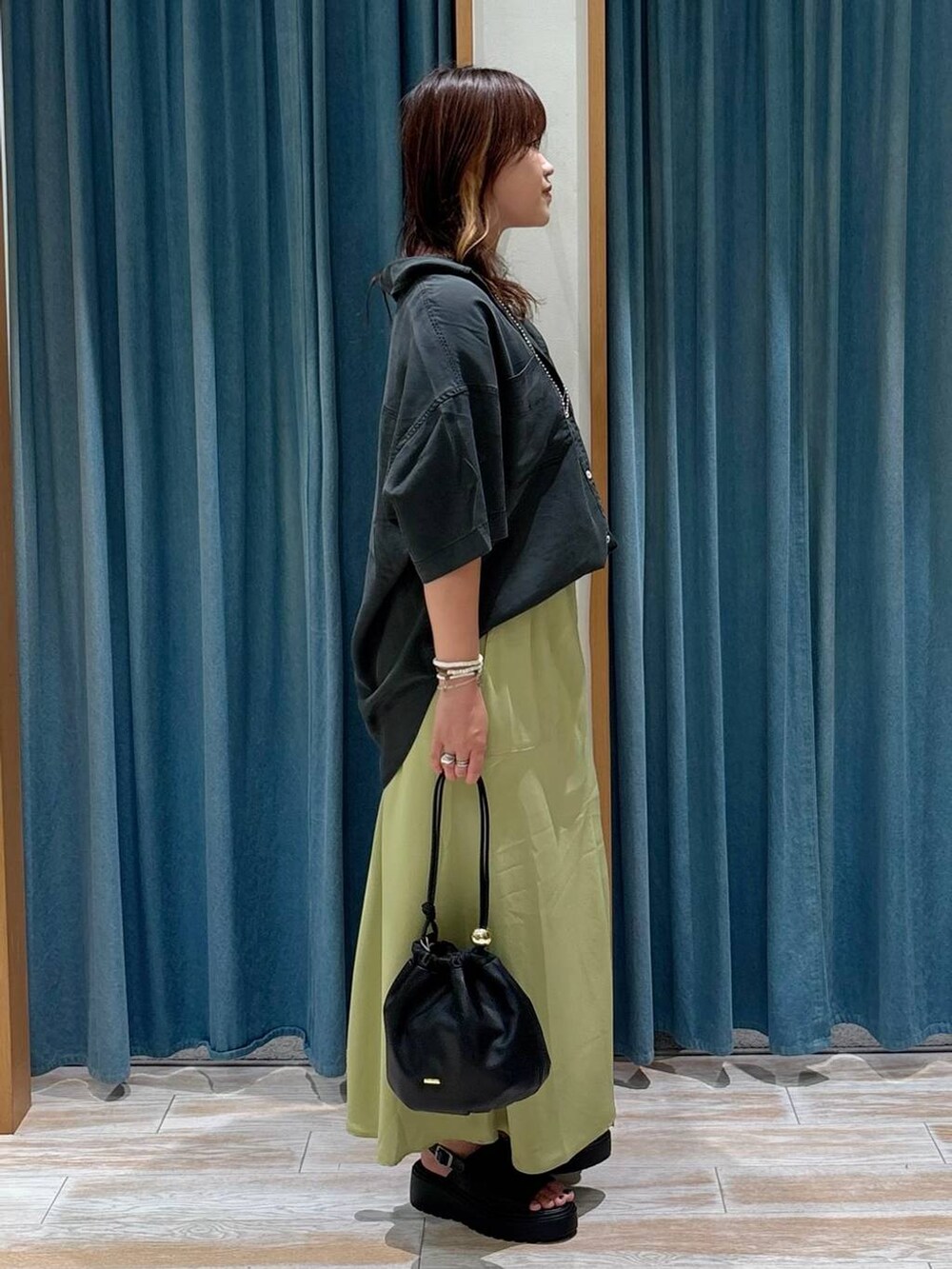 ホワイト系のキャミソール、グレー系のシャツ/ブラウス、ブラック系のショルダーバッグを着用したレディースの夏コーディネートの2枚目の写真