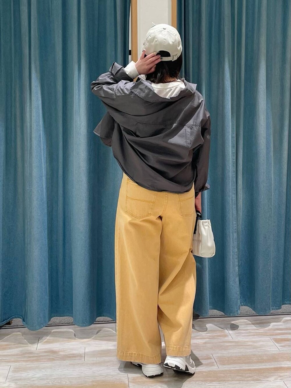 グレー系のシャツ/ブラウス、ベージュ系のショルダーバッグ、ホワイト系のスニーカーを着用したレディースの冬コーディネートの3枚目の写真