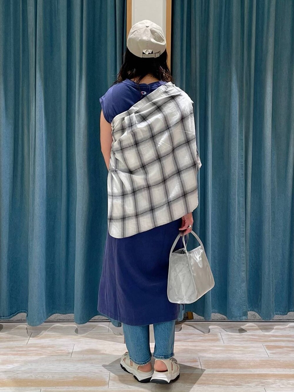 ブルー系のデニムパンツ、ホワイト系のシャツ/ブラウス、ホワイト系のサンダルを着用したレディースの春コーディネートの3枚目の写真