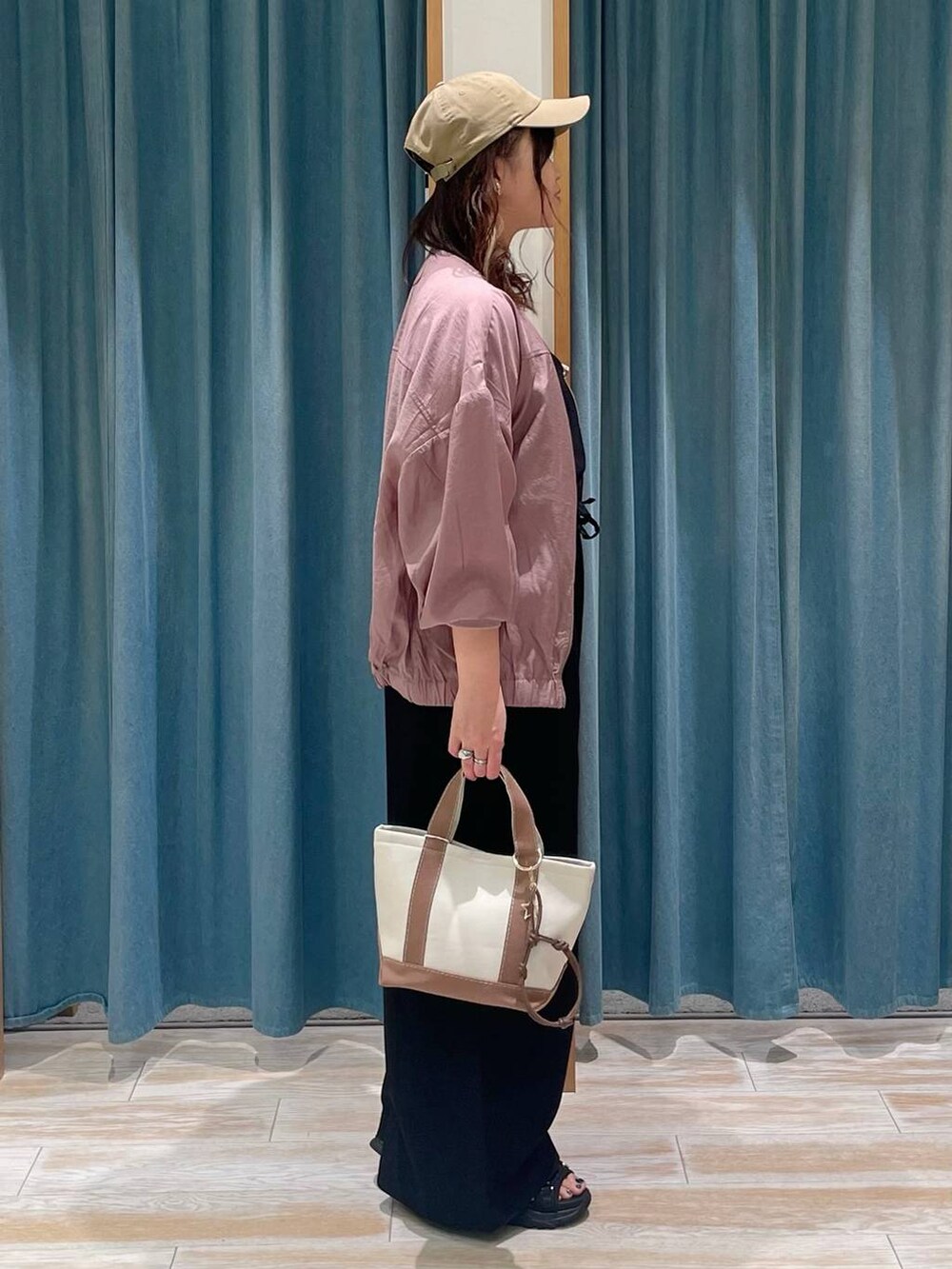 ホワイト系のキャミソール、ブラウン系のトートバッグ、ブラック系のサロペット/オーバーオールを着用したレディースの春コーディネートの2枚目の写真