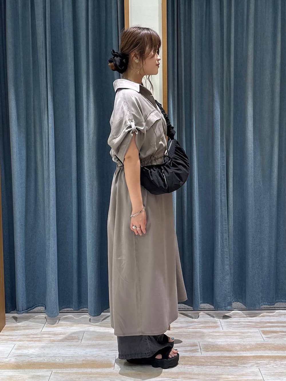 ブラック系のデニムパンツ、ブラック系のショルダーバッグ、ブラウン系のワンピースを着用したレディースの夏コーディネートの2枚目の写真