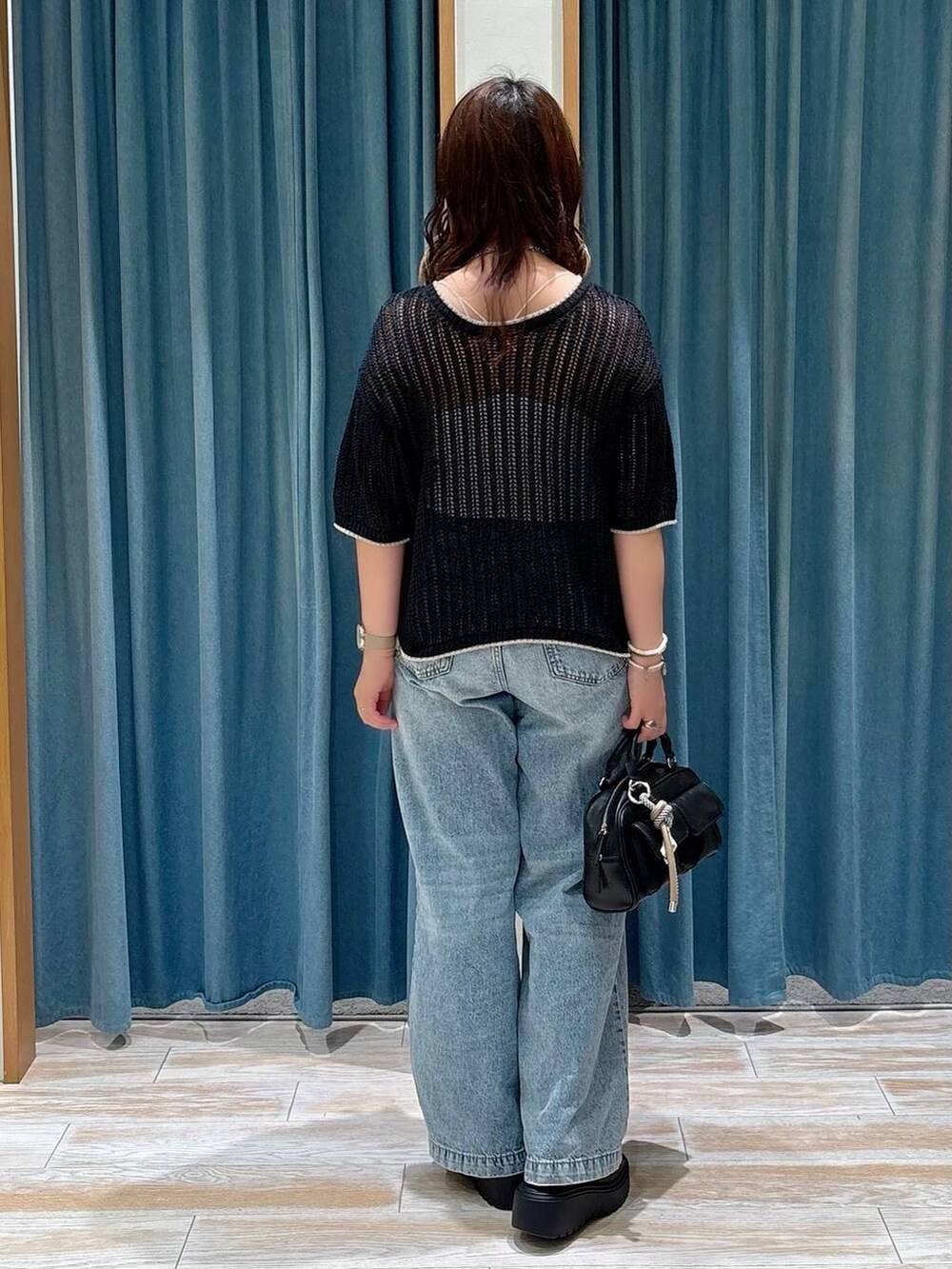 ホワイト系のキャミソール、ブルー系のデニムパンツ、ブラック系のサンダルを着用したレディースの夏コーディネートの3枚目の写真