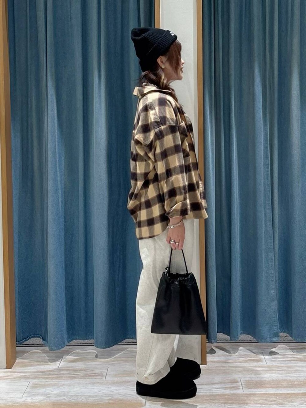 ブラック系のブーツ、ブラック系のハンドバッグ、ベージュ系のシャツ/ブラウスを着用したレディースの秋コーディネートの2枚目の写真