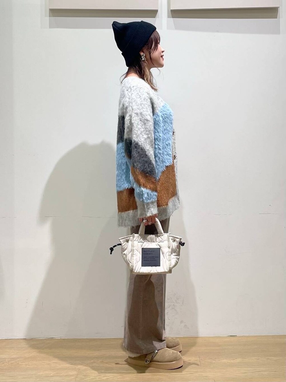 ベージュ系のその他パンツ、ホワイト系のショルダーバッグ、ホワイト系のキャミソールを着用したレディースの秋コーディネートの2枚目の写真