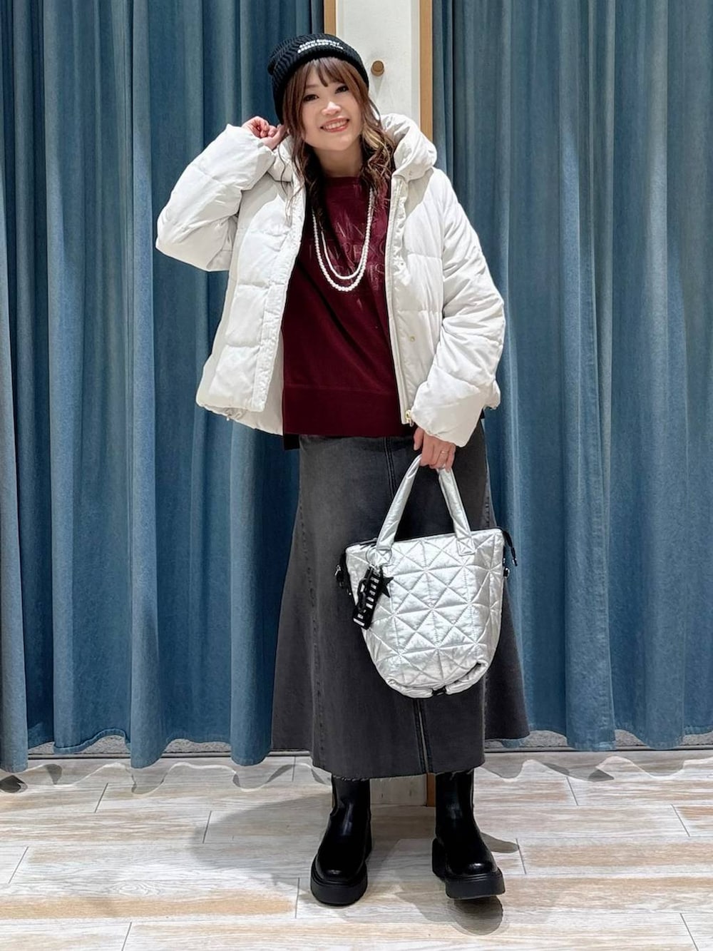 ベージュ系のダウンジャケット/コート、ブラック系のブーツ、ブラック系のスカートを着用したレディースの秋コーディネートの4枚目の写真