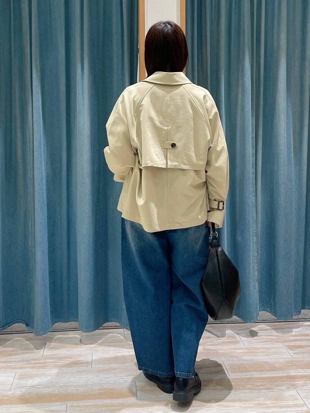 ベージュ系のトレンチコート、ブルー系のデニムパンツ、ホワイト系のTシャツ/カットソーを着用したレディースの冬コーディネートの3枚目の写真