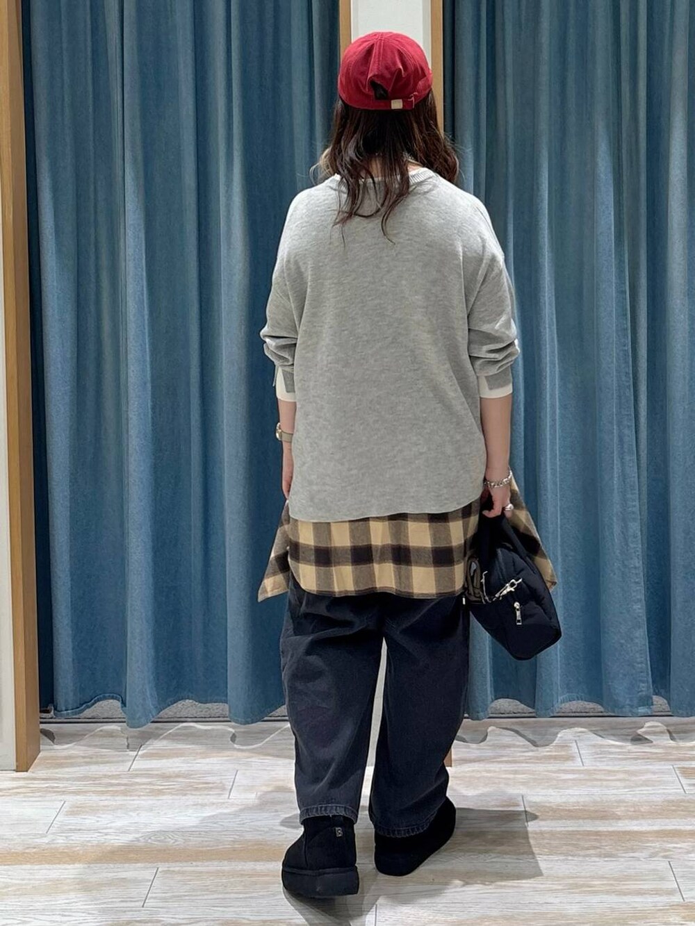 ブラック系のブーツ、グレー系のニット/セーター、ブラック系のボストンバッグを着用したレディースの秋コーディネートの3枚目の写真