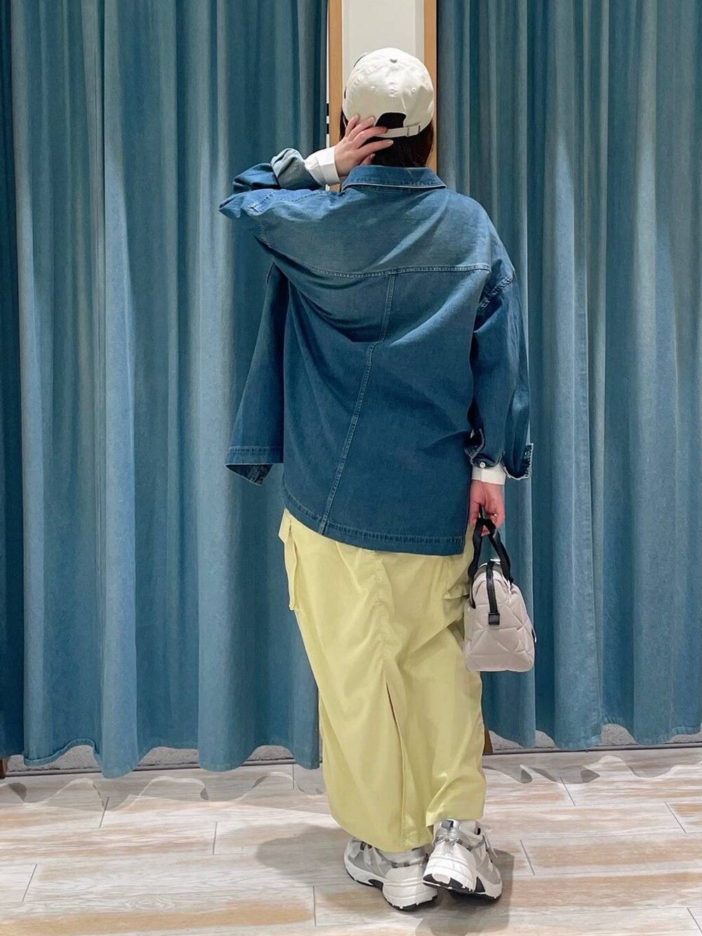 ホワイト系のTシャツ/カットソー、ベージュ系のハンドバッグ、ホワイト系のスニーカーを着用したレディースの春コーディネートの3枚目の写真