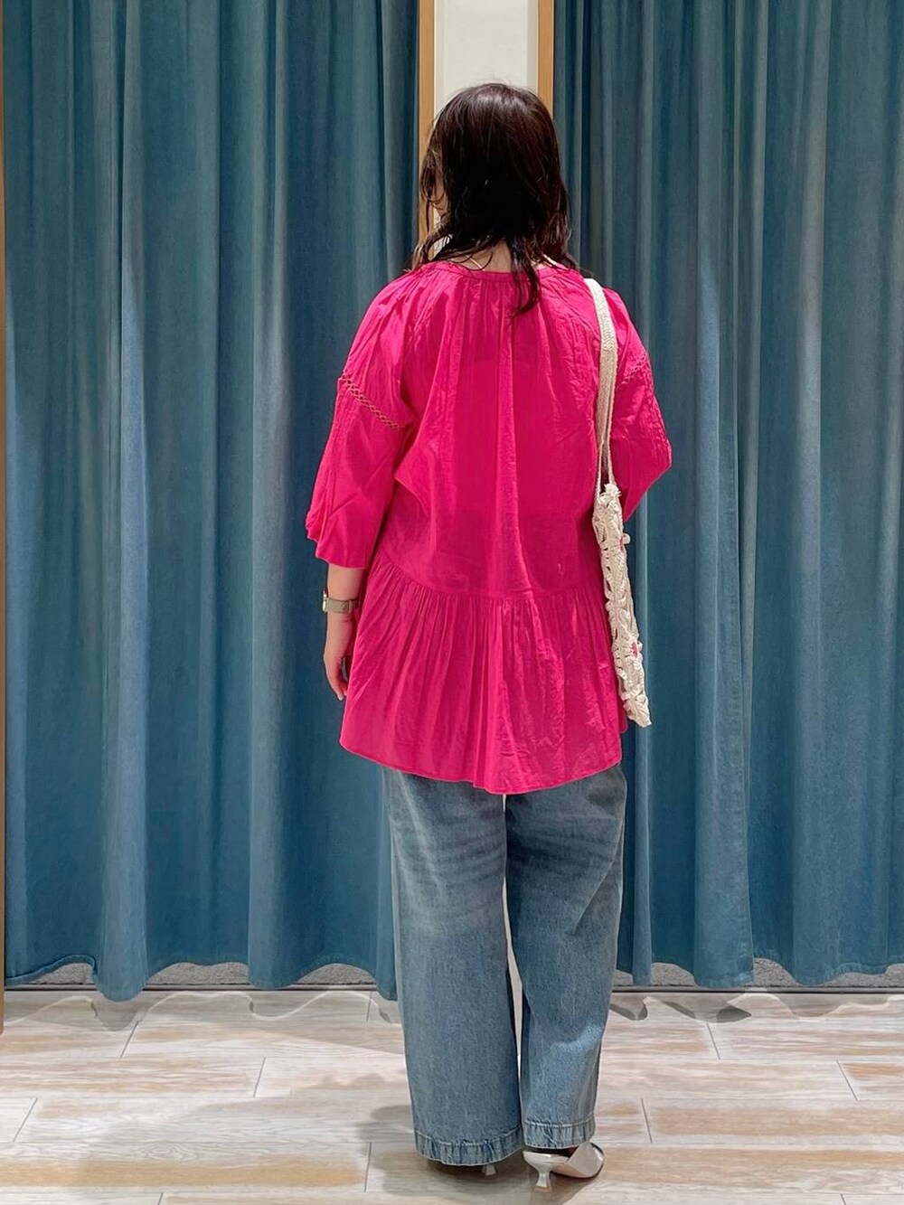 ホワイト系のキャミソール、シルバー系のサンダル、ブルー系のデニムパンツを着用したレディースの春コーディネートの3枚目の写真