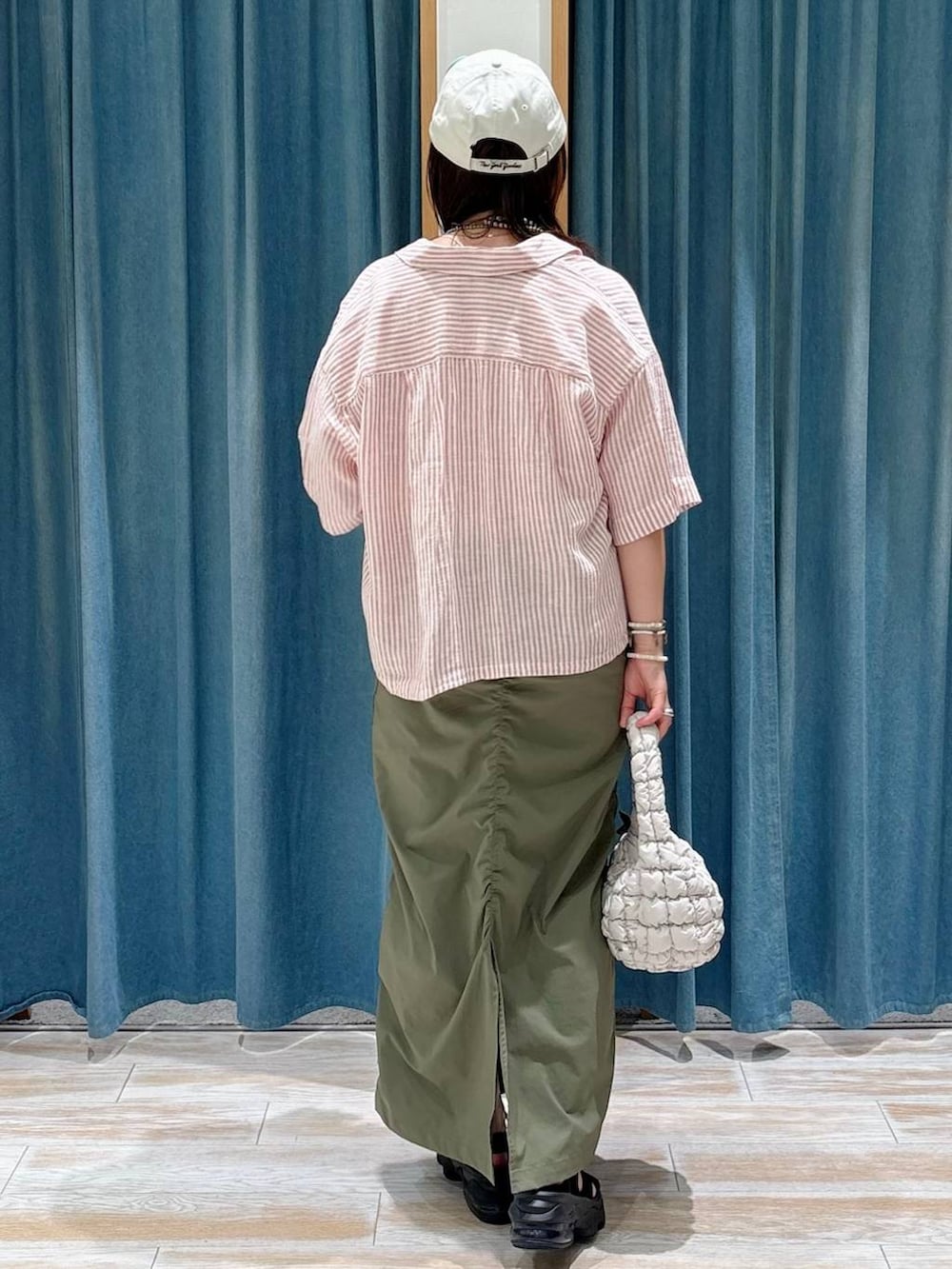 ホワイト系のキャミソール、グリーン系のスカート、レッド系のシャツ/ブラウスを着用したレディースの夏コーディネートの3枚目の写真