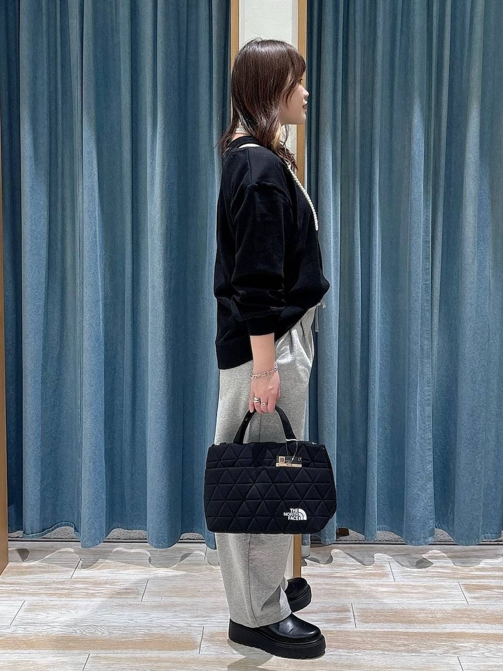 ブラック系のブーツ、ブラック系のトートバッグ、グレー系のその他パンツを着用したレディースの冬コーディネートの2枚目の写真