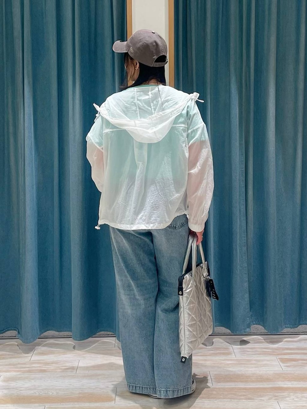 グリーン系のTシャツ/カットソー、ブルー系のデニムパンツ、シルバー系のトートバッグを着用したレディースの春コーディネートの3枚目の写真