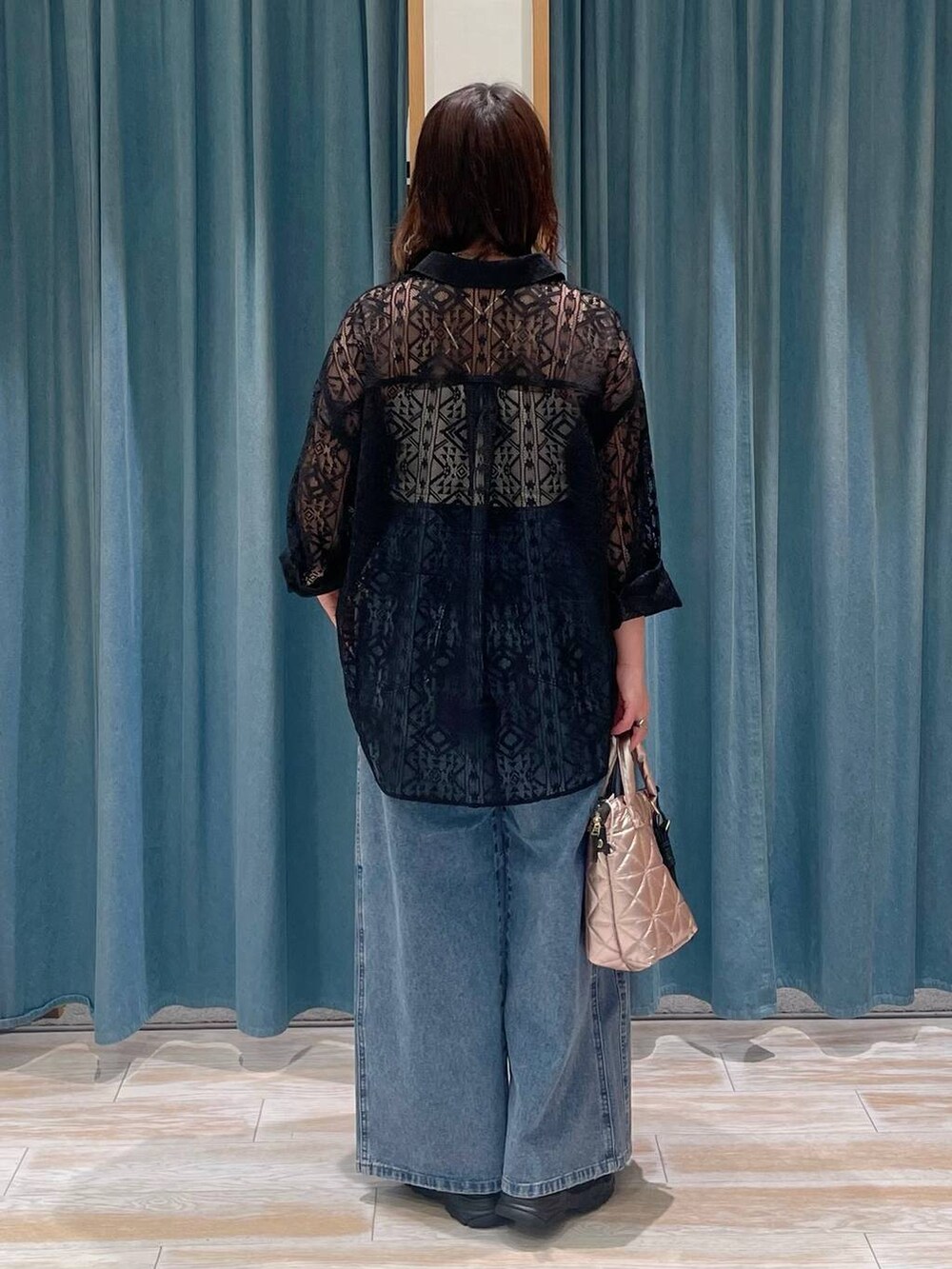 ホワイト系のキャミソール、ブルー系のデニムパンツ、ピンク系のハンドバッグを着用したレディースの春コーディネートの3枚目の写真