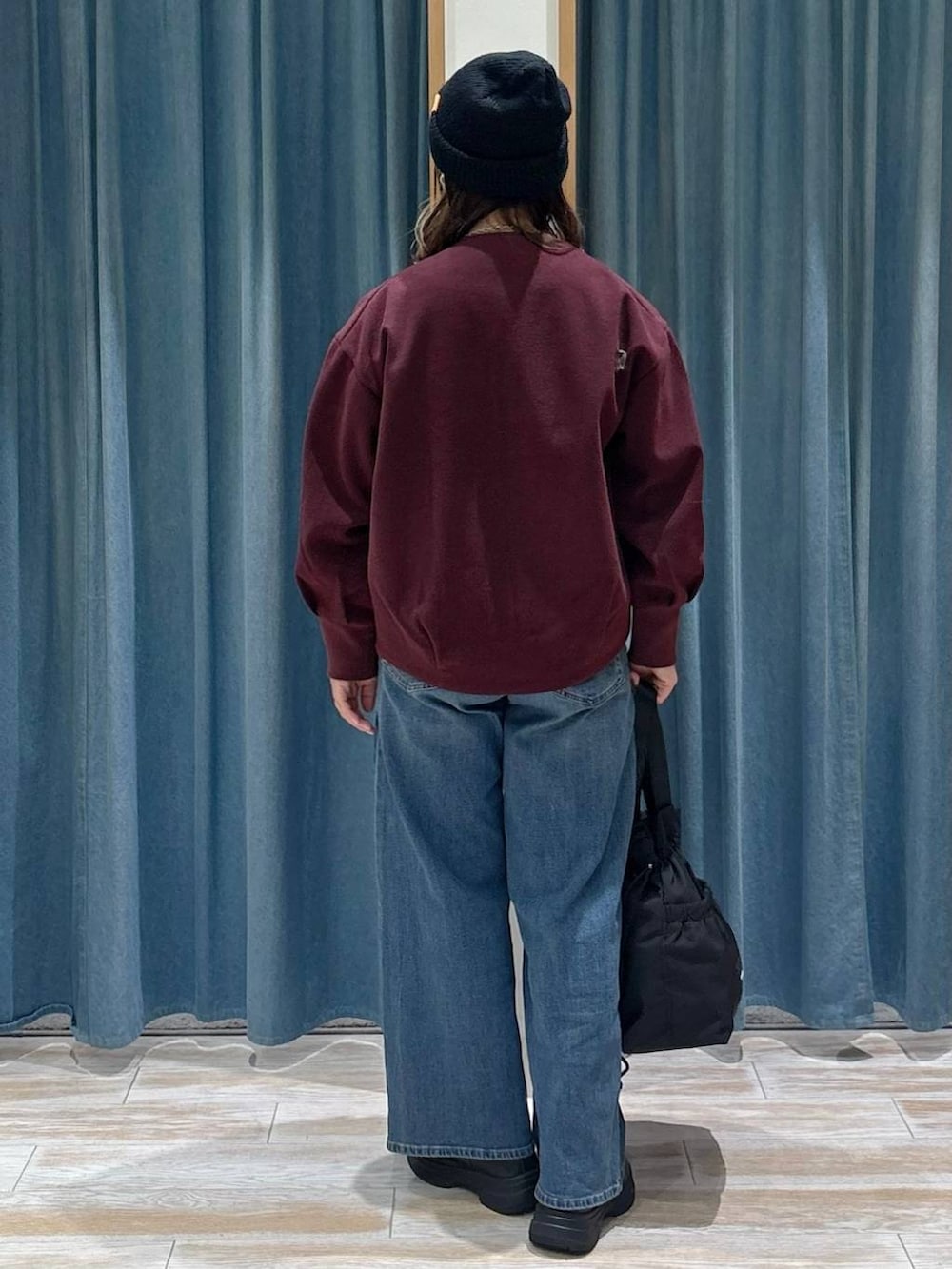 ブラック系のトートバッグ、レッド系のブルゾン、グレー系のベストを着用したレディースの秋コーディネートの3枚目の写真