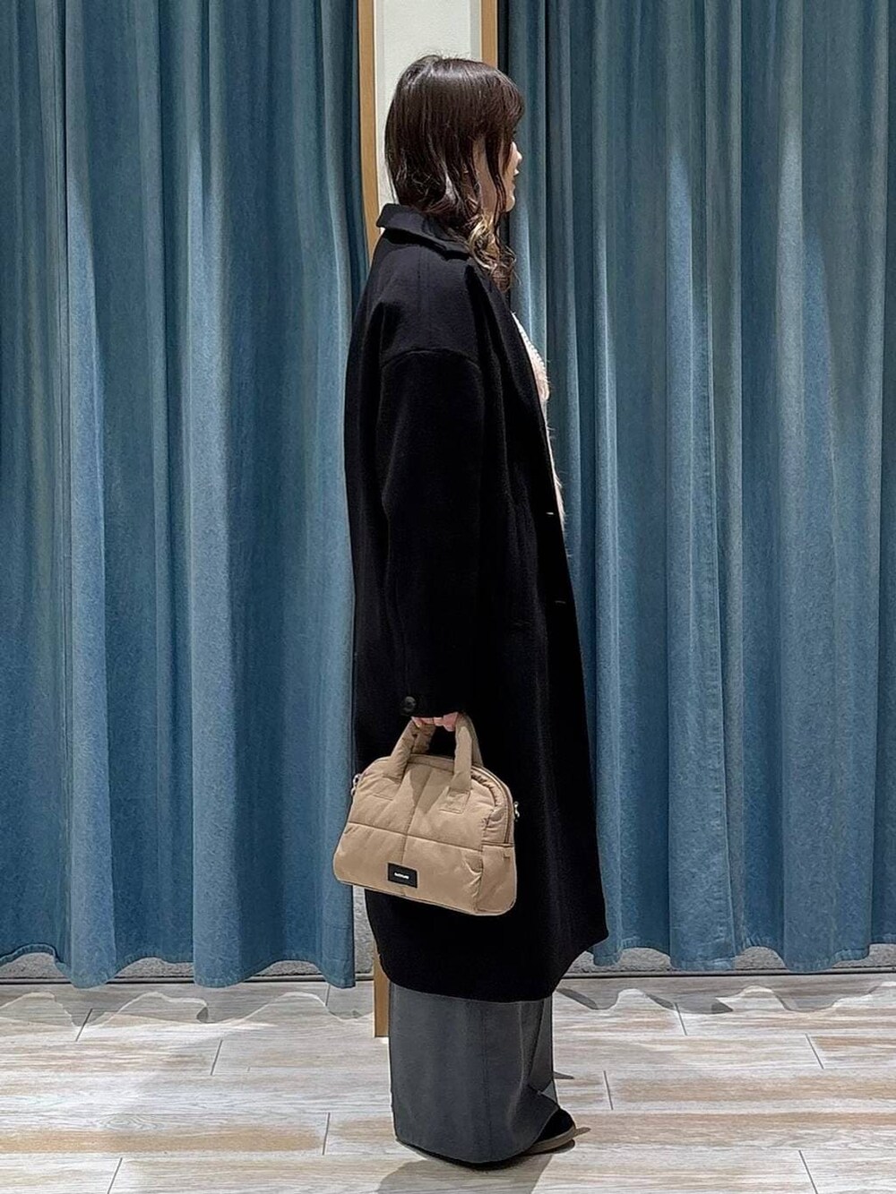 グレー系のその他パンツ、ブラック系のチェスターコート、ブラック系のスニーカーを着用したレディースの冬コーディネートの2枚目の写真