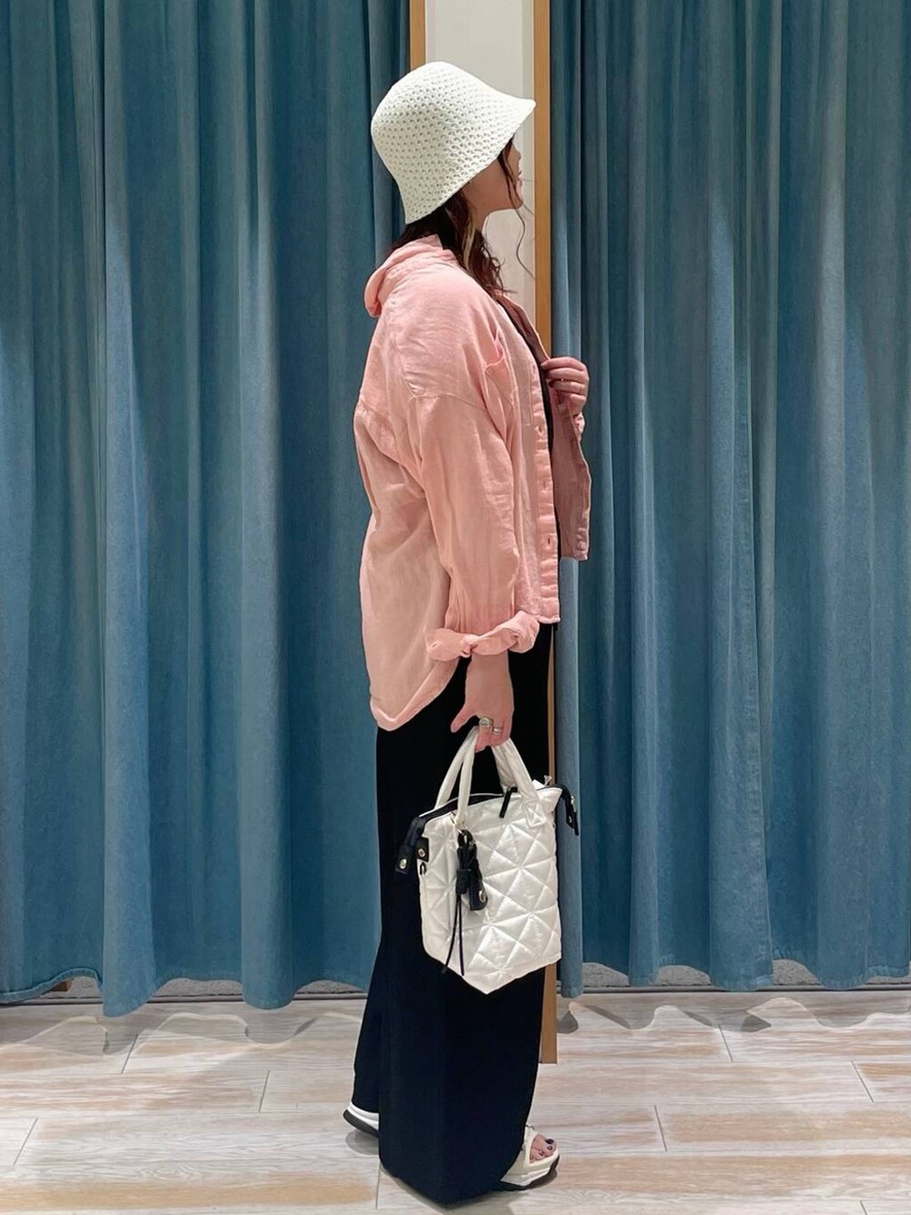 ホワイト系のキャミソール、ブラック系のサロペット/オーバーオール、ホワイト系のハンドバッグを着用したレディースの春コーディネートの2枚目の写真