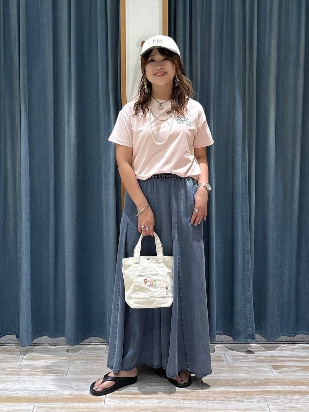 ピンク系のTシャツ/カットソー、ブルー系のスカート、ブラック系のサンダルを着用したレディースの夏コーディネートの4枚目の写真