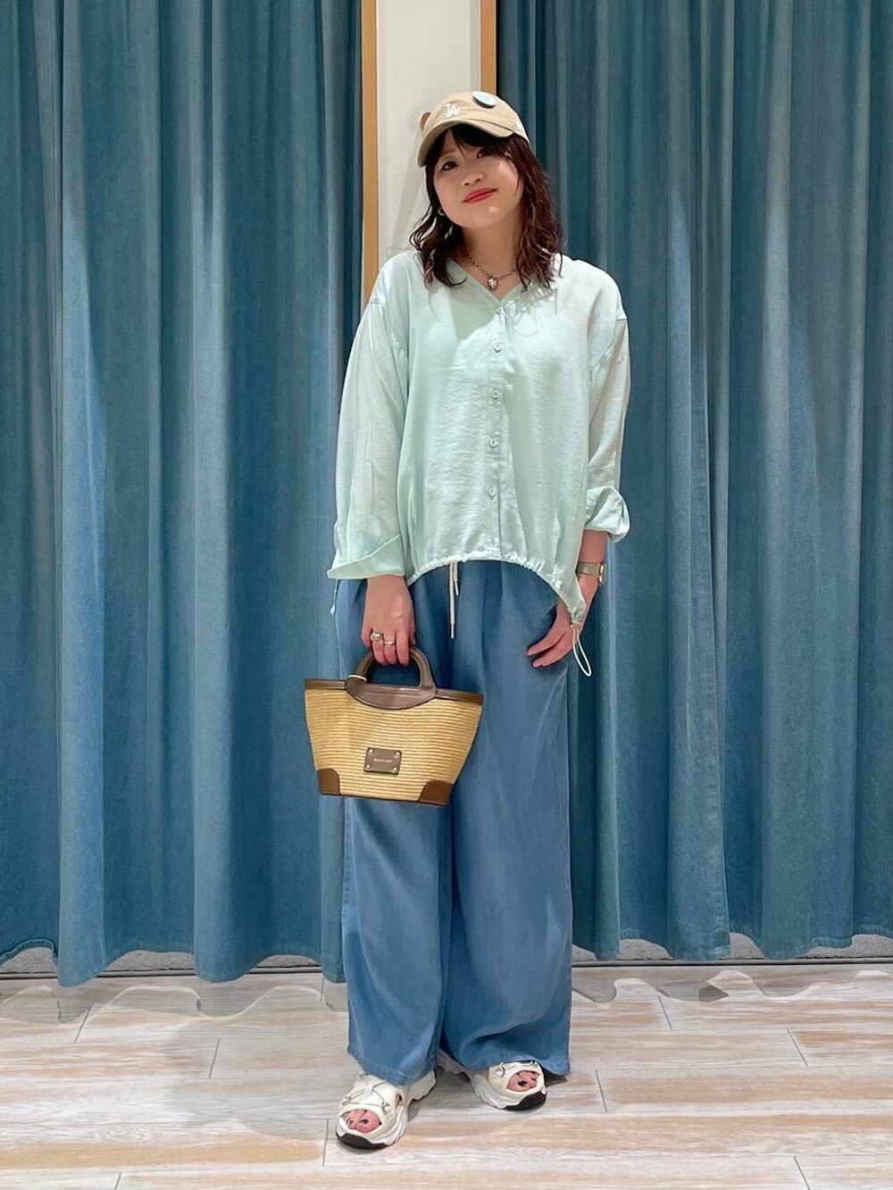 ブラウン系のショルダーバッグ、ブルー系のその他パンツ、グリーン系のシャツ/ブラウスを着用したレディースの春コーディネートの4枚目の写真